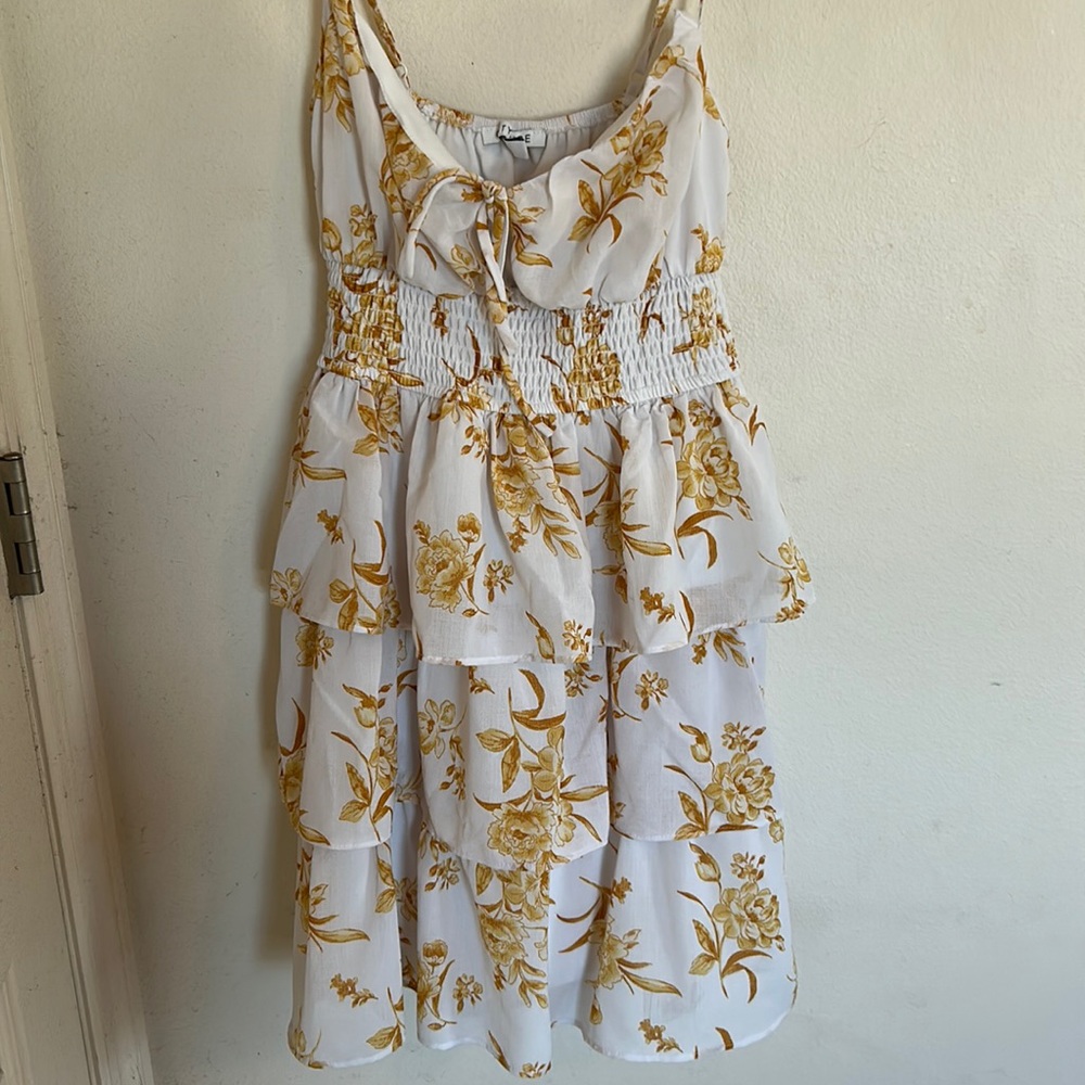 Gold floral sundress with ruffles on the bottom.